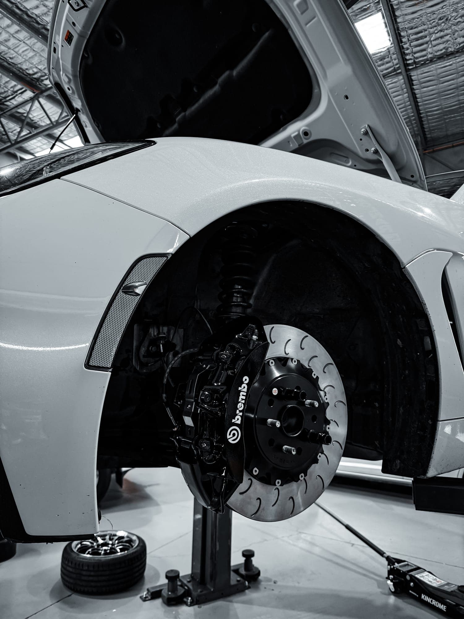 Brembo big brake kit installed - black caliper and slotted two-piece rotor