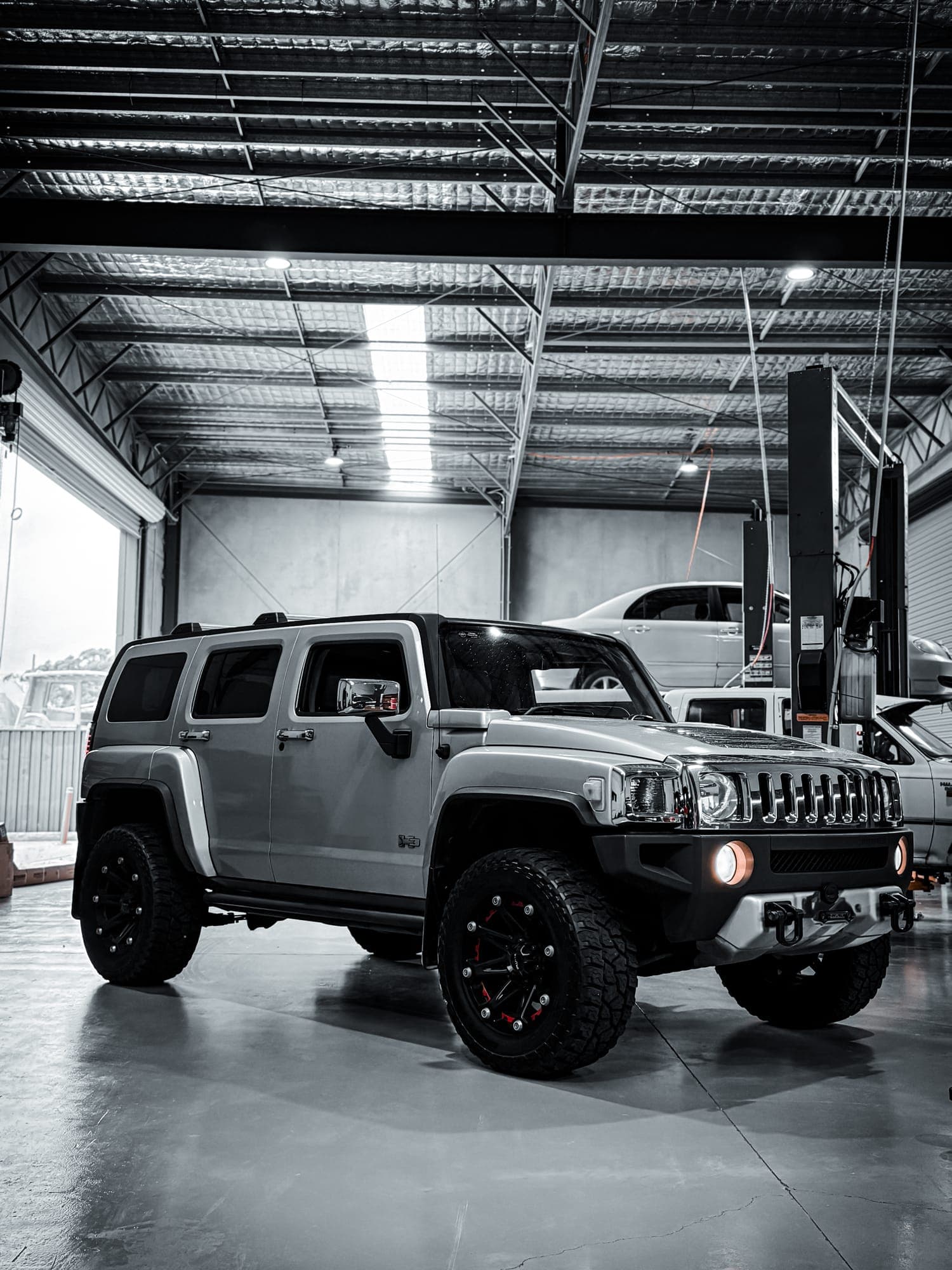 Lifted Hummer H3 on custom wheels and all-terrain tyres in the workshop