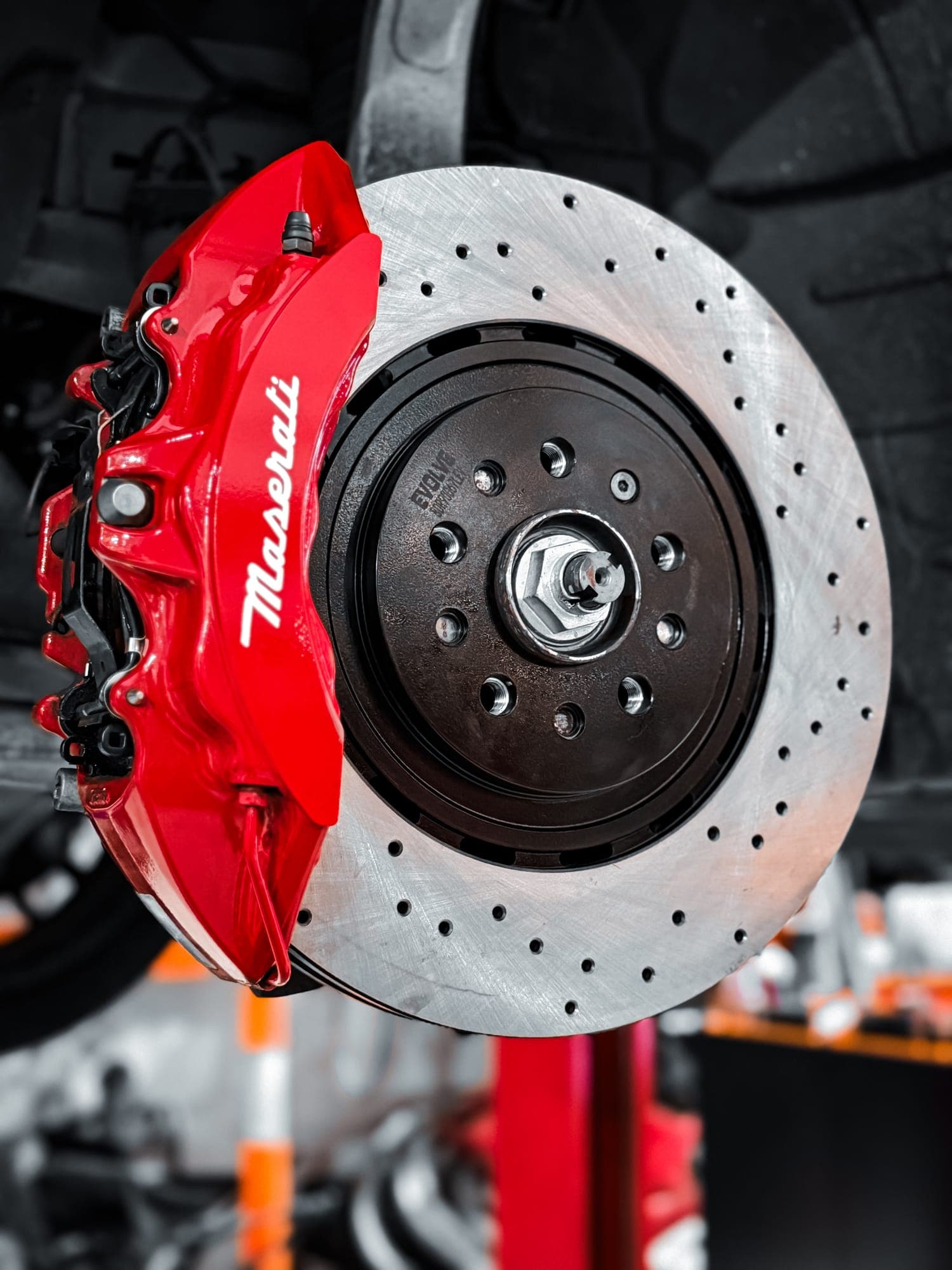 Maserati red brake caliper and drilled rotor during brake service
